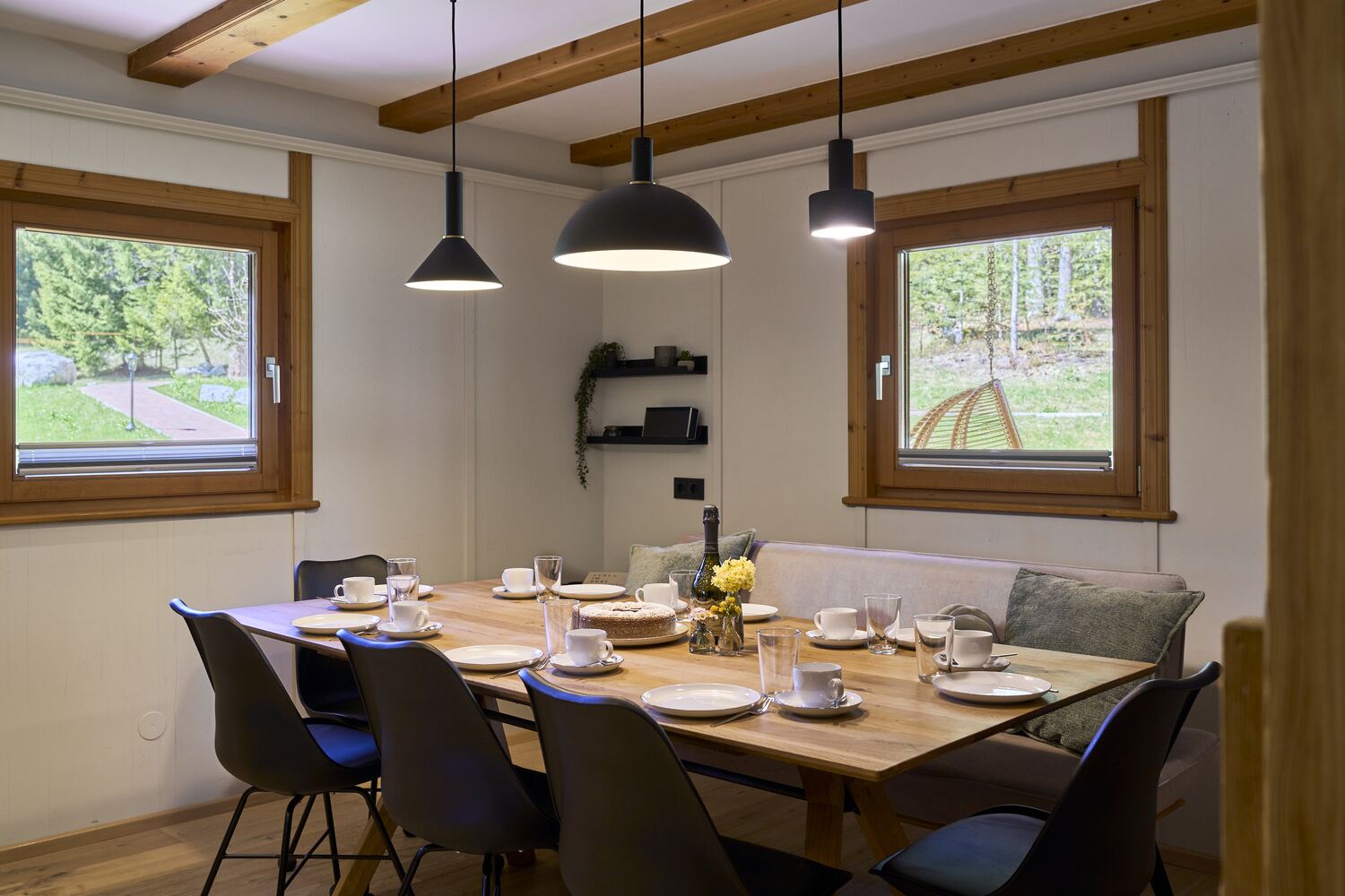 Bright kitchen and dining room with wooden floor, a laid table and open kitchen